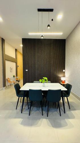 a dining room with a white table and chairs at Chani House Hatyai in Hat Yai