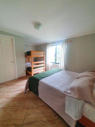 a bedroom with a large bed and a bunk room at Nido Del Bosque in Pucón