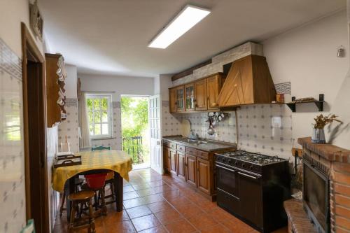 a kitchen with a table and a stove top oven at Casa Dona Aninhas - Douro in Moura Morta