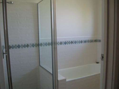a bathroom with a shower with a tub and a sink at Hayden House in Delegate