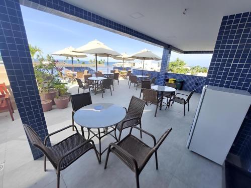 patio ze stołami, krzesłami i parasolami w obiekcie Flat Porto Blue 103 - Centro Porto de Galinhas w mieście Porto de Galinhas