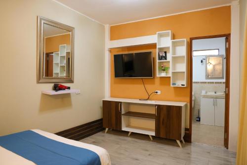 una camera d'albergo con un letto e una televisione di Casa MANCORA a Máncora