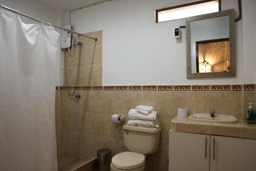 ein Badezimmer mit Toilette, Waschbecken und Spiegel in der Unterkunft Casa MANCORA in Máncora
