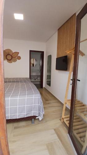 a bedroom with a bed and a television in it at Pousada Solarium in Canoa Quebrada