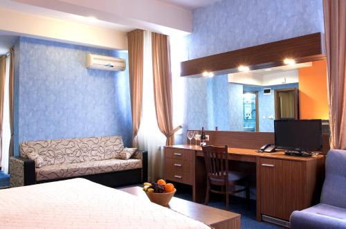 een hotelkamer met een bed en een bureau met een computer bij DITER Family Hotel in Sofia