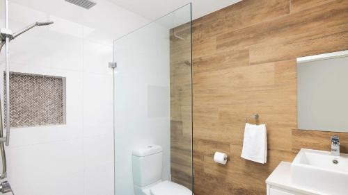 a bathroom with a shower and a toilet and a sink at Chill Out at Fingal Jellicoe Close in Fingal Bay