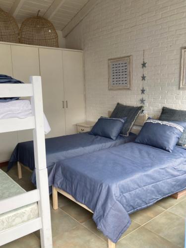 1 Schlafzimmer mit 2 Betten mit blauer Bettwäsche und einer Leiter in der Unterkunft Casa en La Barra in Punta del Este