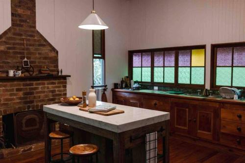a kitchen with a table and a counter with stools at Baxter Lodge - Hinterland Country Luxury in Mapleton
