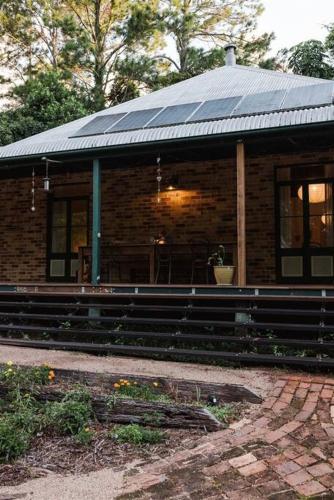 a brick building with a roof with a porch at Baxter Lodge - Hinterland Country Luxury in Mapleton