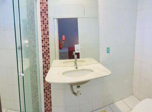 インダイアトゥーバにあるEm frente ao Polo Shoppingの洗面台とシャワー付きの白いバスルーム