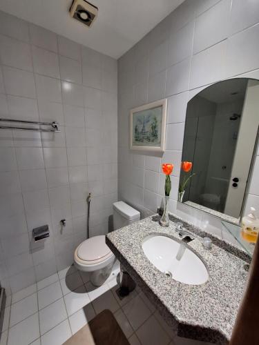 a bathroom with a sink and a toilet and a mirror at Costa Oeste Itaparica in Itaparica Town