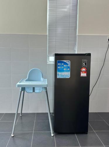 a blue stool next to a small refrigerator at May Homestay in Port Dickson