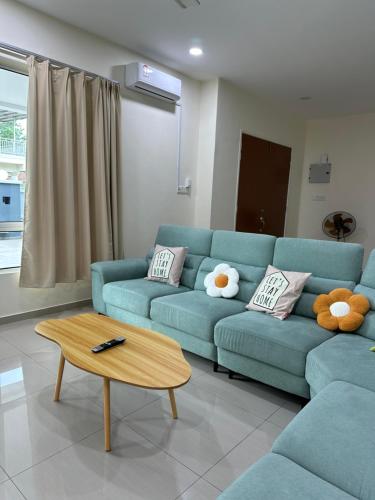 a living room with a blue couch and a coffee table at May Homestay in Port Dickson