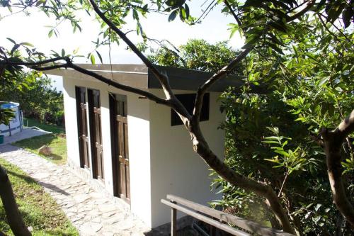 a white building with a bench in front of it at Private Costa Rica Mountain House Pool & Stunning Views in Turrialba