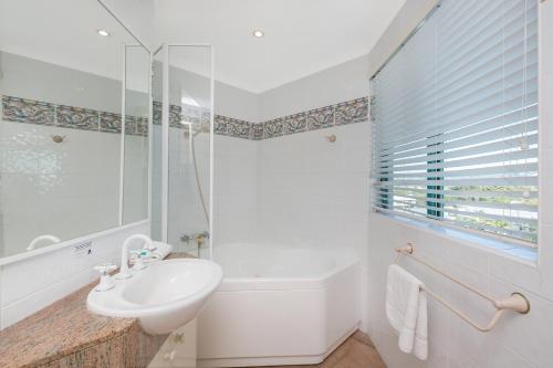 a white bathroom with a sink and a shower at Argyle on the Park in Maroochydore