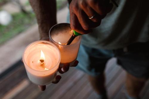 a person is lighting a candle with a lighter at Baxter Lodge - Hinterland Country Luxury in Mapleton