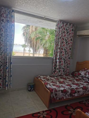 ein Schlafzimmer mit einem Bett und einem großen Fenster in der Unterkunft شاليه الهنا 1 للإيجار مصيف قرية النورس الإسماعيلية in Ismailia