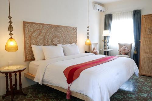 a bedroom with a large bed and a window at Su's Cottages Legian in Legian