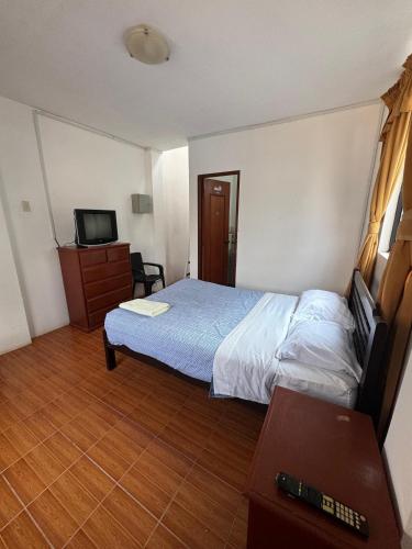 a hotel room with a bed and a television at La Arteza Pacasmayo in Pacasmayo
