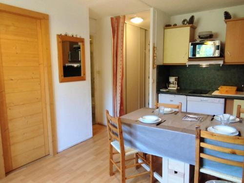 une cuisine avec une table et des chaises dans une pièce dans l'établissement Appartement 2 Pièces aux Pieds des Pistes, Terrasse, Proche Remontées - FR-1-771-53, à Les Adrets