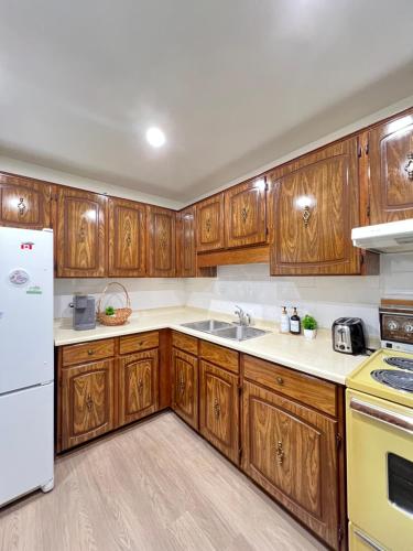 a kitchen with wooden cabinets and a white refrigerator at Entire House-3BRM-14 mins from Niagara Falls in Thorold