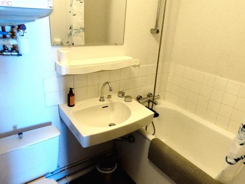 une salle de bain blanche avec un lavabo et une baignoire dans l'établissement Appart 2 pièces au pied des pistes, 1 chambre, 141 m², ascenseur, casier ski - FR-1-771-34, à Les Adrets