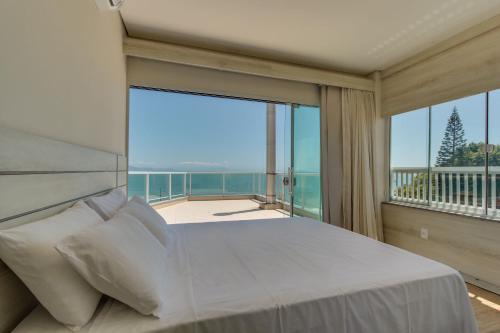 フロリアノポリスにあるImigrantes Apart Hotelの大きなベッドとバルコニーのある寝室