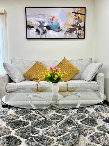 a living room with a couch and a glass coffee table at Entire House-3BRM-14 mins from Niagara Falls in Thorold