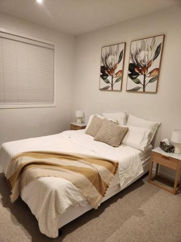 a bedroom with a bed with two pictures on the wall at Mt Eden Kingsland At the heart of it all in Auckland