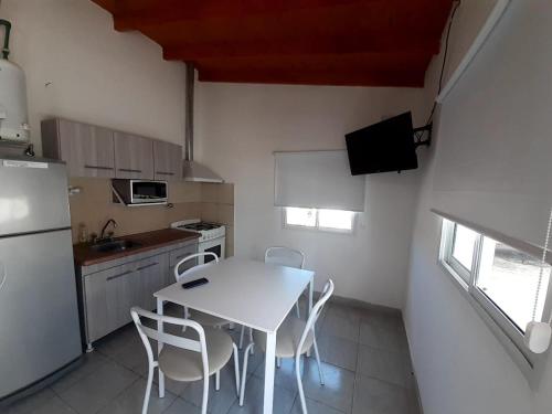 a small kitchen with a white table and chairs at Gotas de Rocio in San Antonio Oeste
