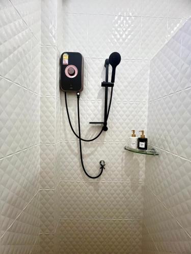 a shower with a phone on a wall in a bathroom at N&D Poolvilla in Ao Nang Beach