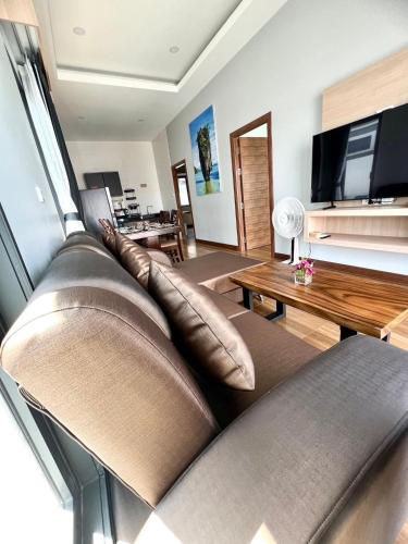 a living room with a couch and a television at N&D Poolvilla in Ao Nang Beach