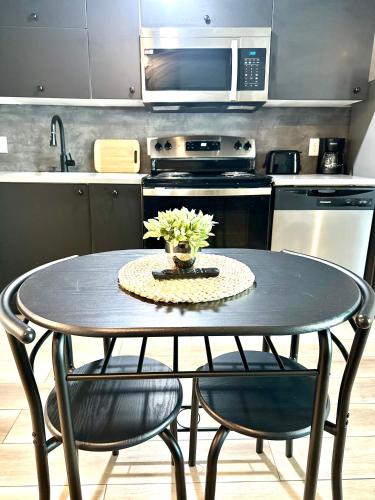 a kitchen with a table with two chairs and a microwave at Newly renovated apartment in the heart of Detroit! in Detroit