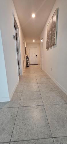 an empty hallway with a tile floor and white walls at Cozy house with a Heated Swim spa in Port Charlotte