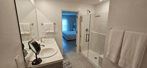 a white bathroom with a sink and a shower at Cozy house with a Heated Swim spa in Port Charlotte