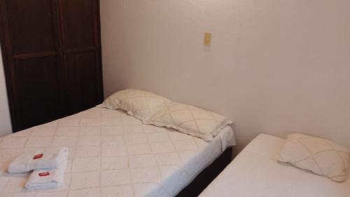 a small bedroom with two beds with towels on them at Hostal casa de los sueños in Villa de Leyva