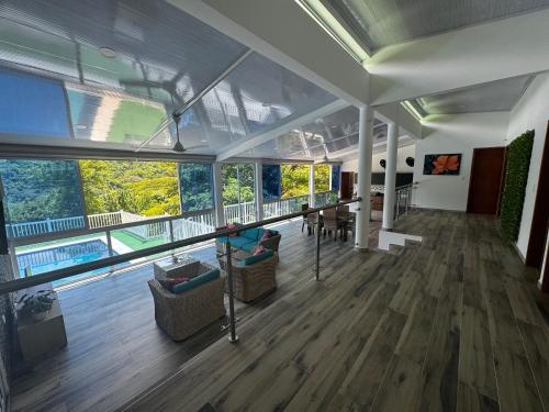 a large room with wooden floors and large windows at Kulcana - Cerros del Guacaná in Tocaima