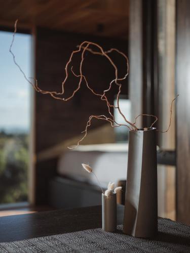a metal vase with branches in it on a table at The Tailored Pod - A Compact Oasis in Lewisham