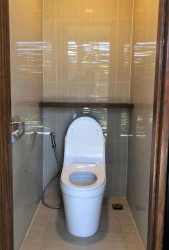 a bathroom with a toilet with the lid up at Cocoons Club Laiya in Batangas City