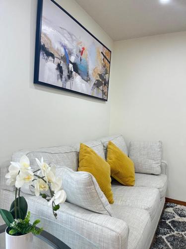 a couch with yellow pillows and a painting on the wall at Entire House-3BRM-14 mins from Niagara Falls in Thorold