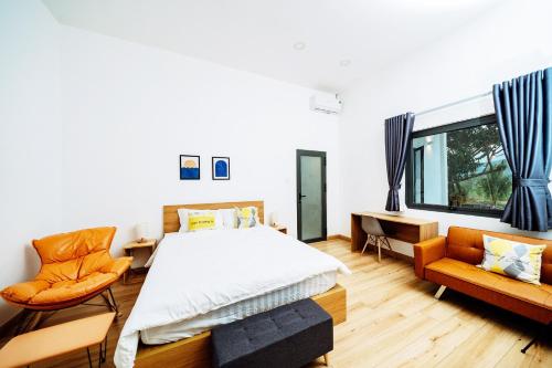 a bedroom with a bed and two orange chairs at Sol Valley - Hideaway Station in Blao Srê