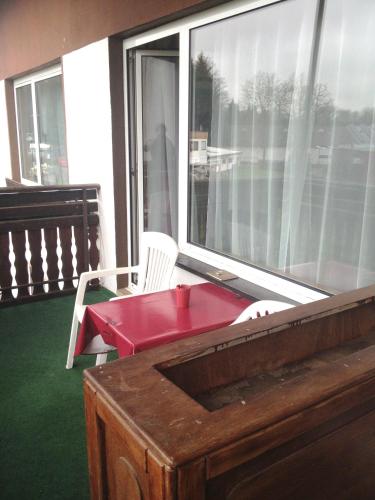 a balcony with a red table and a chair at Hotel Saarland Lebach in Lebach