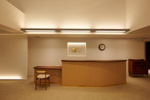 a waiting room with a desk and a clock on the wall at Shin-Osaka Station Hotel in Osaka