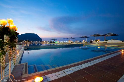 a swimming pool with a view of the ocean at night at La Marsa Vacances in Mondello