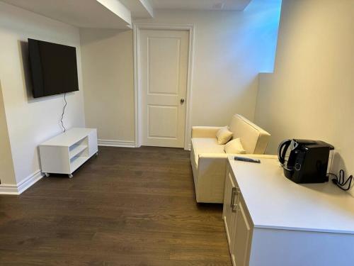 Una sala de estar con un sofá y un televisor. en Cozy Home away in Ajax 2 BR 1 bath 4 guests, en Ajax