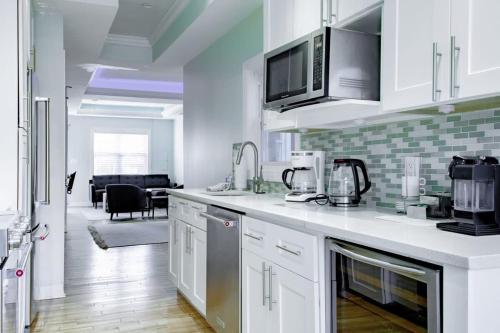a kitchen with white cabinets and a living room at MODERN HOME NEAR CAPITOL HILL - Walk to METRO subway in Washington, D.C.
