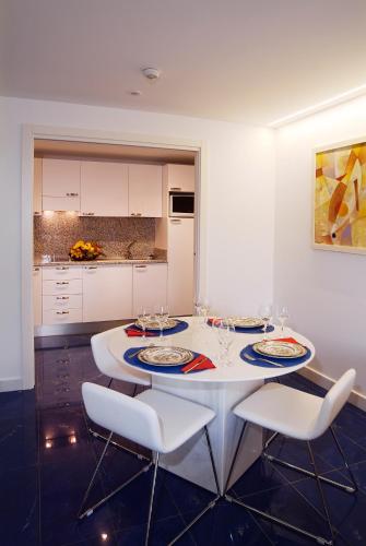 a kitchen with a white table and chairs with wine glasses at El Greco in Puerto Rico de Gran Canaria