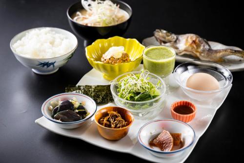 a plate with bowls of food on a table at glampark Hinokiyunoyado Nagano in Azumino