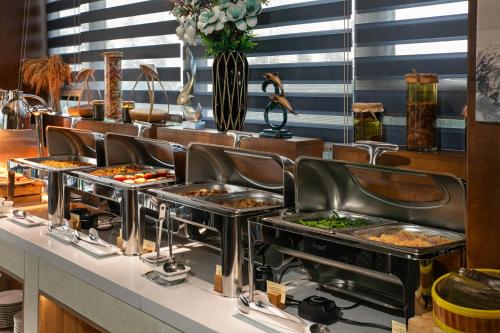 een rij dienbladen eten op een buffetlijn bij Mangata Beachfront Hotel - Rooftop Bar Sea View in Da Nang