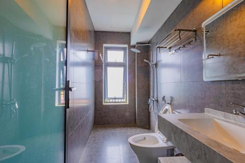 a bathroom with a toilet and a sink and a shower at Green House - Căn hộ có bếp riêng in Da Lat